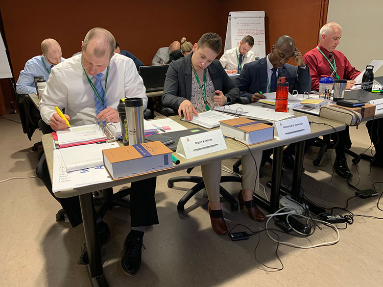 people sitting at rows of tables writing on paper