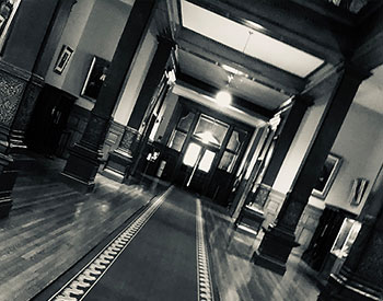 une photo en noir et blanc du couloir de l'édifice de l'Assemblée legislative