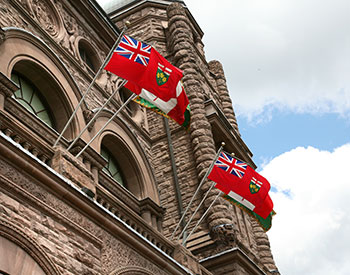 deux drapeaux de l'Ontario flottant devant le Palais législatif