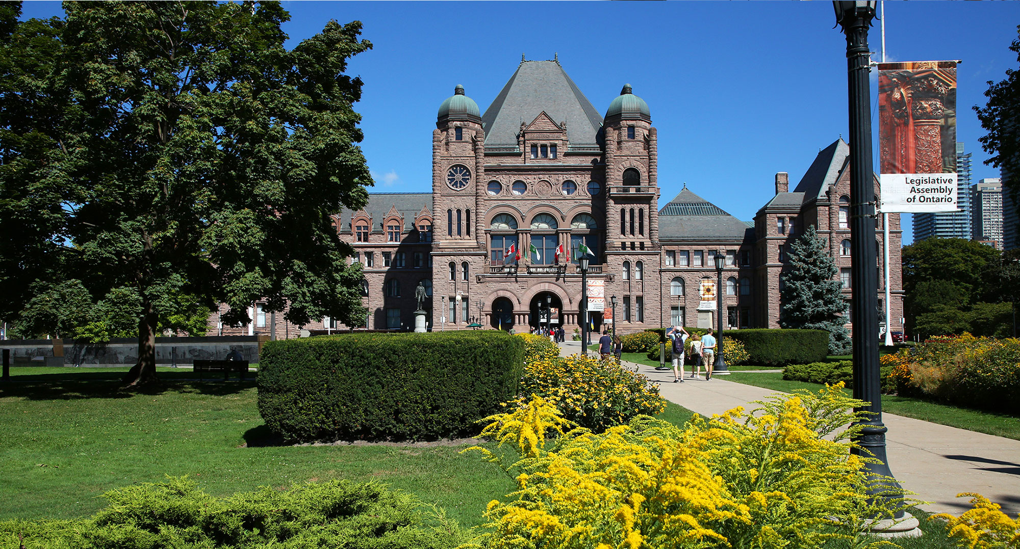 front lawn of Legislative Assembly with trees and buildings in background