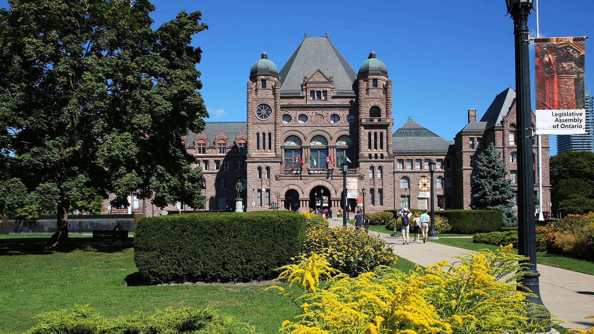 front lawn of Legislative Assembly with trees and buildings in background