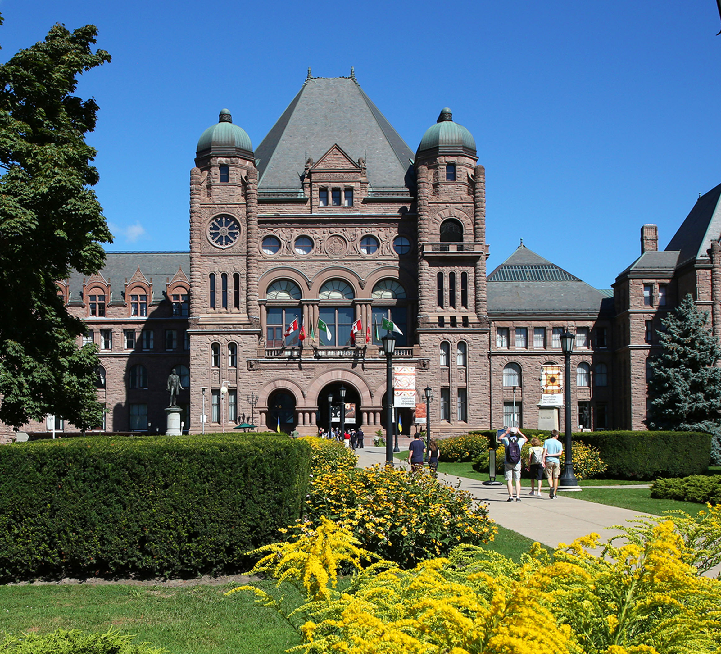 front lawn of Legislative Assembly with trees and buildings in background